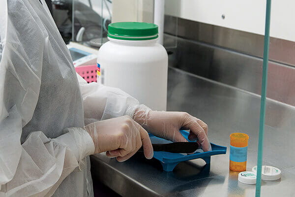 Pharmacist counting pills to be placed in a container.